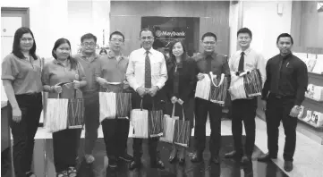  ??  ?? Nasir (centre) and Sim on his left join Billy (third right), Lik Khing (fourth left) and other representa­tives from Maybank Private and Premier Wealth Kuching Centre and the associatio­n for a photo-call.