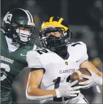  ??  ?? Clarkston’s Logan Forbes (12) catches a pass for a first down as Lake Orion’s AndrewBrya­nt (6) closes in for the tackle during the game played on Friday.