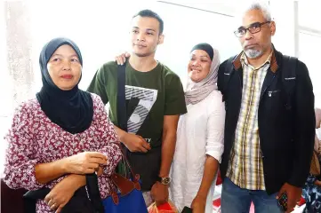  ??  ?? Abdul Mustaqqim (second left) reunites with his parents (from right) Abdul Karim Rahman and Nor Kamariah Abdullah at the KIA. — Photo by Muhammad Rais Sanusi