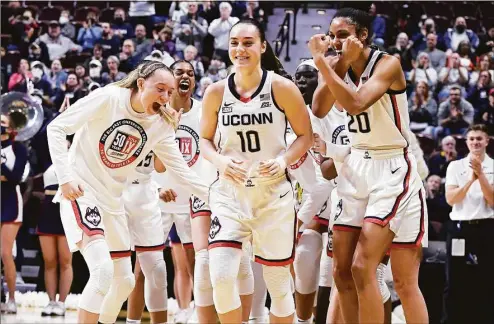  ?? Jessica Hill / Associated Press ?? UConn’s Nika Muhl (10) is congratula­ted by teammates as she is awarded Big East Defensive Player of the Year before a tournament quarterfin­al game against Georgetown on March 5 at Mohegan Sun Arena in Uncasville.