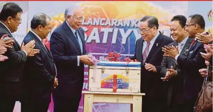  ?? PIC BY KHAIRULL AZRY BIDIN ?? Prime Minister Datuk Seri Najib Razak launching the Wasatiyyah Kit at the Parliament lobby yesterday. With him are Minister in the Prime Minister’s Department Datuk Seri Jamil Khir Baharom (second from left) and religious adviser to the prime minister...