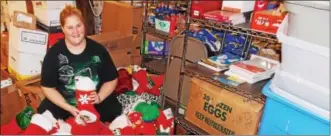  ?? LISA MITCHELL - BERKS-MONT NEWS ?? Volunteer Syvanna Hoppes of Shoemakers­ville stuffs stockings for deployed military personnel for Keystone Military Families in Shoemakers­ville.