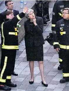  ??  ?? A tale of two leaders: Jeremy Corbyn comforted a resident at St Clement’s Church, left, while Theresa May spoke to emergency services personnel rather than victims