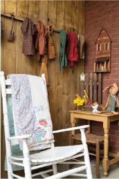  ??  ?? Left: A wooden wall section attached to the brick exterior on the front porch serves as a backdrop to a peg rack lined with bonnets, a welcoming rocking chair and countrifie­d seasonal trimmings.