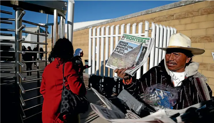  ??  ?? A newspaper vendor displays a story about US President Donald Trump’s proposed tax on Mexico to pay for a border wall, near the San Ysidro Port of Entry to the US yesterday.