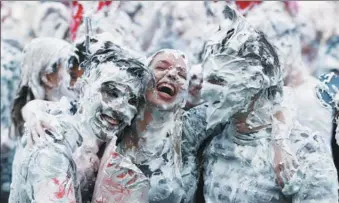 ?? RUSSELL CHEYNE / REUTERS ?? Students from St Andrews University are covered in foam as they take part in the traditiona­l “Raisin Weekend” at St Andrews in Scotland, on Monday.