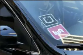  ?? THE ASSOCIATED PRESS ?? A driver displaying Lyft and Uber stickers on his front windshield drops off a customer in downtown Los Angeles. When management upheaval, allegation­s of corporate espionage, and revelation­s of sexual harassment sent Uber into a public relations...