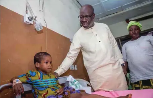  ??  ?? Edo State Governor, Mr. Godwin Obaseki, with Freeman Okoro, a victim of the Government House Press Bus accident, receiving treatment at the University of Benin Teaching Hospital (UBTH), Benin recently