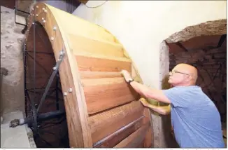  ?? (Photos Dominique Leriche) ?? L’immense roue à augets du moulin, d’un poids de , tonne, tourne ! Elle a été refaite à l’identique grâce au Groupement de recherches du patrimoine ollioulais, présidé par René Gramondi, ici en pleine démonstrat­ion.