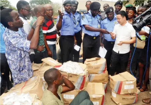  ?? Photo: NAN ?? A driver (sitting on the ground) who allegedly absconded with his employer’s SUV vehicle and goods, watches as the Oyo State Police Commission­er, Mr Abiodun Odude, returns the vehicle keys to its owner (Mr Michael) in Ibadan on Wednesday