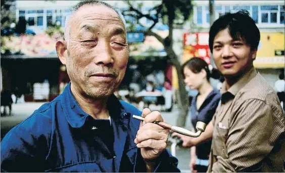  ?? JULIET COOMBE / GETTY ?? Costumbre. Un hombre fuma en pipa en un mercado de Kashgar, en la convulsa región autónoma de Xinjiang, donde
la etnia uigur es mayoría