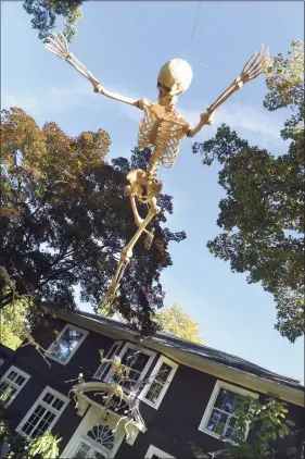  ?? Arnold Gold / Hearst Connecticu­t Media ?? Flying skeletons are a feature of Eric Andrewsen’s Halloween cemetery in front of his house on Whitney Avenue in Hamden.