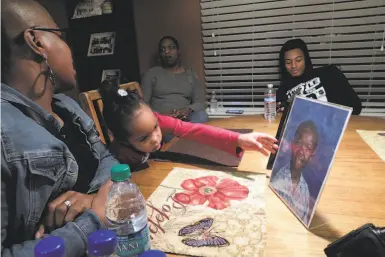  ?? Photos by Carlos Avila Gonzalez / The Chronicle ?? Peyton McCoy, 3, reaches for a photo of her uncle, Willie McCoy, who was shot dead by Vallejo police Feb. 9.