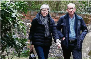  ?? — AFP ?? Staying on: May arriving with her husband Philip to attend a church service near her Maidenhead constituen­cy, west of London.