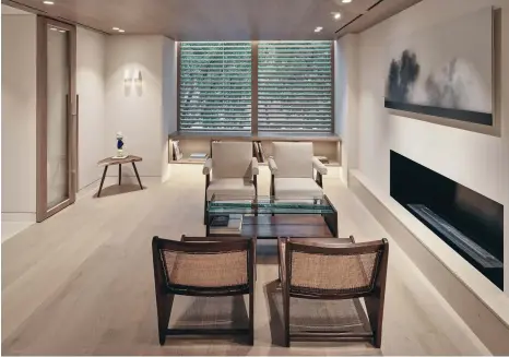  ??  ?? Bottom
The lounge area of the wellness space features original Pierre Jeanneret chairs and a landscape painting by Korean artist Kibong Rhee, which stand out against a neutral materials palette