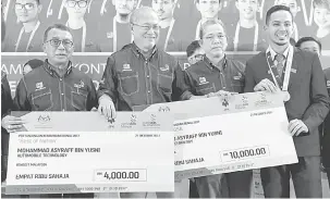  ?? — Gambar Bernama ?? INSENTIF: Richard Riot (dua kiri) menyampaik­an replika cek bernilai RM10,000 dan RM4,000 kepada pemenang pingat gangsa dalam bidang Teknologi Automotif, Mohd Ashraff Yusni (kanan) dari Kolej Universiti DRB Hicom pada majlis sambutan kontinjen negara...