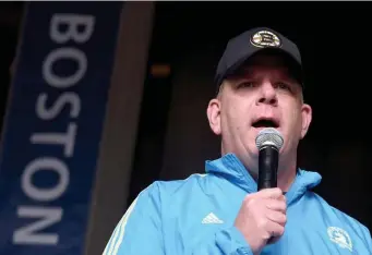  ?? BOSTON HERALD FILE ?? ‘OVERREACTI­ON’: Mayor Martin Walsh, seen speaking at the pasta dinner on the eve of last year’s Boston Marathon, says this year’s race will go on. At left, runners at a marathon in Japan wear surgical masks.