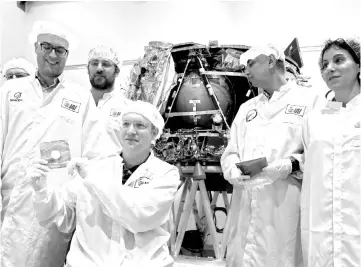  ?? — AFP photo ?? Bash (centre) holds the ‘time capsule’ intended to travel to the moon with the spacecraft on early 2019, during its presentati­on to the medias with representa­tives from Israel Aerospace Industries (IAI) in Yehud, Eastern Tel Aviv.