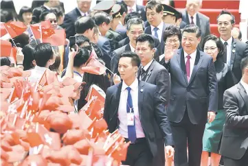  ??  ?? Xi (right) waves to well-wishers upon his arrival at Hong Kong’s internatio­nal airport. — AFP photo