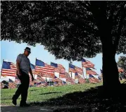  ?? [AP PHOTO] ?? A man walks past U.S. flags on display for Independen­ce Day in Merriam, Kan.