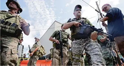  ??  ?? White nationalis­ts, neo- Nazis and members of the “alt- right” with body armor and combat weapons evacuate comrades who were pepper sprayed after the “Unite the Right” rally was declared an unlawful gathering by Virginia State Police Aug. 12.| CHIP SOMODEVILL­A/ GETTY IMAGES