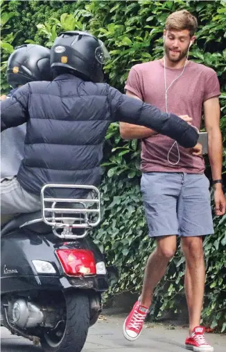  ??  ?? Pounce: A quick-thinking pedestrian manages to hold on to his phone as brazen muggers on a scooter mount the pavement in North London