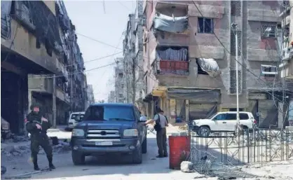  ?? Reuters ?? A Russian soldier holds his weapon at the city of Douma in Damascus on Friday.