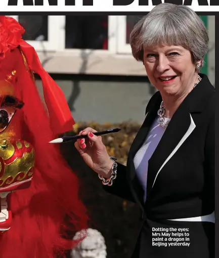  ??  ?? Dotting the eyes: Mrs May helps to paint a dragon in Beijing yesterday