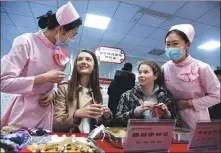  ?? LI ZIHENG / XINHUA ?? Students from China University of Petroleum experience traditiona­l Chinese medicine techniques at a TCM cultural base in Qingdao, Shandong province, on April 23.