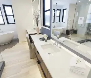  ?? PHOTOS: IAN KUCERAK ?? The Lamia’s ensuite has dual vanities separated by a makeup desk. There’s also a freestandi­ng tub and glassed-in shower.