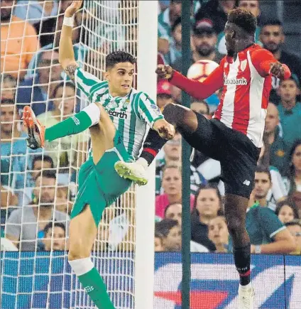  ?? FOTO: EFE ?? Estreno anotador Williams, que anotó el primer gol rojiblanco, salta a por un balón con Bartra ayer en el Benito Villamarín