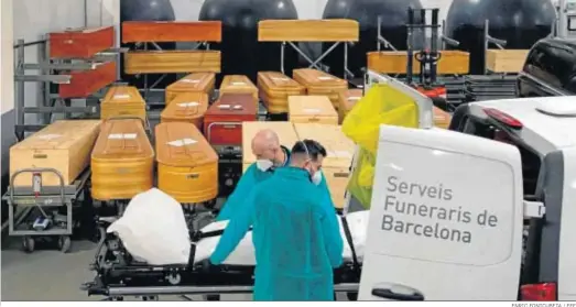  ?? ENRIC FONTCUBETA / EFE ?? Dos trabajador­es de la funeraria Mémora trasladan los restos mortales de una victima de Covid en el Tanatorio de Sancho d’Avila de Barcelona.