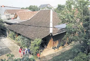  ?? ?? Hiyashinta Klise hangs laundry outside her traditiona­l Javanese house that uses solar panels, in Bekasi, near Jakarta.