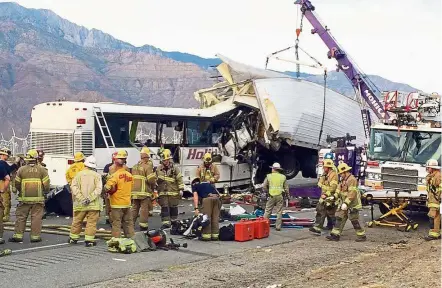  ?? — AP ?? Fatal accident: Emergency personnel working at the scene where a tour bus crashed into the rear of the container truck north of the desert resort town of Palm Springs, California.