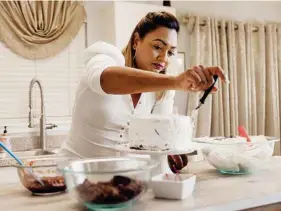  ?? ALFONSO DURAN/THE NEW YORK TIMES ?? Natasha Laggan, who runs a Trinidadia­n cooking account on Instagram and YouTube, makes a Black Forest cake in Davie, Fla.