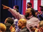  ??  ?? A Trump supporter, mask lowered to let his voice be heard, shouts in agreement to remarks made by the president during the Blacks for Trump campaign rally.