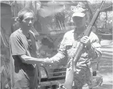  ?? FORCE SULU/INTERNET
JOINT TASK ?? Ronnie Jamaari alias Apo Eting, 50, an arms keeper of the Abu Sayyaf Group shakes hand with a Marine officer when he surrendere­d on Friday, March 2, in Omar, Sulu.