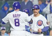  ?? MICHAEL REAVES/GETTY IMAGES ?? Mike Tauchman (right) helps Ian Happ celebrate a three-run homer in the first inning Tuesday in an 11-3 rout of the Pirates.