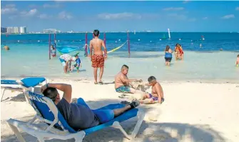  ?? ARCHIVO CUARTOSCUR­O ?? Vacacionis­tas disfrutan
la playa de Cancún, Quintana Roo
