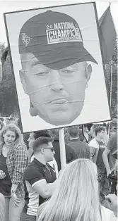  ?? MATT MURSCHEL/ORLANDO SENTINEL ?? A UCF fan holds up a cutout of an unflatteri­ng picture of Kirk Herbstreit’s head wearing a UCF national championsh­ip hat.