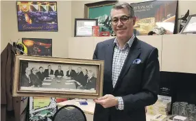  ?? HILARY KLASSEN ?? TCU Place CEO Bob Korol holds a photo of the visionarie­s who ensured plans for TCU Place went forward in 1968. From left: W. A. Milne, W. H. L. Godsalve, S. L. Buckwold,
R. M. Aikenhead, O. B. Nelson, J. M. Byers, D. M. Koyl, C. J. Wheaton, A. C. McEown