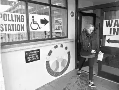  ??  ?? A woman leaves the polling station at St. Patrick’s Primary school after voting in Clonoe, Northern Ireland. — Reuters photo