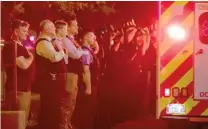  ?? ASHLEE REZIN/ SUN- TIMES ?? Chicago fire and police personnel salute as emergency vehicles, including the ambulance carrying the body of Juan Bucio, travel to the medical examiner’s office.