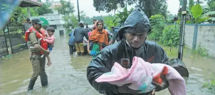  ??  ?? Fire and rescue personnel evacuate local residents from a flooded area at Muppathada­m near Eloor in Kochi’s Ernakulam district, in the Indian state of Kerala on August 15, 2018.