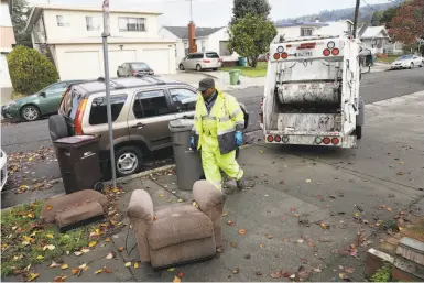  ?? Photos by Lea Suzuki / The Chronicle ?? Oakland maintenanc­e worker Ayinde Osayaba prepares to haul away a chair abandoned on the street.