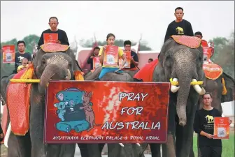  ?? SOE ZEYA TUN / REUTERS ?? Students and a troupe of ten elephants on Monday in Ayutthaya, Thailand, pray for Australia as bushfires rage.