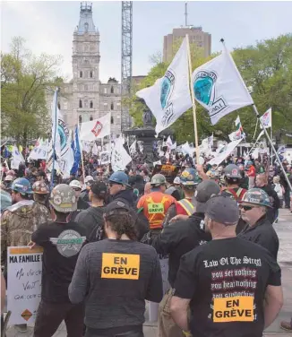  ?? JACQUES BOISSINOT LA PRESSE CANADIENNE ?? Des travailleu­rs en grève du secteur de la constructi­on ont manifesté devant l’Assemblée nationale, lundi, tandis qu’à l’intérieur, les députés entreprena­ient l’étude du projet de loi 142 forçant le retour au travail.