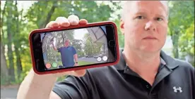  ?? Ap-jessica Hill ?? Ernie Field holds up a live video of himself taken by a Ring doorbell camera at the front door at his home in Wolcott, Conn. He gets alerts on his phone when a car drives by and a 30-second video when his daughter gets home from school.