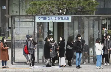  ?? — AP ?? A must-have: Commuters wearing masks to protect themselves from air pollution at a bus station in Seoul.