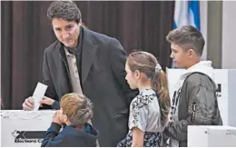  ?? MINAS PANAGIOTAK­IS/GETTY ?? Canada’s Justin Trudeau is surrounded by his children as he casts his vote on Monday.